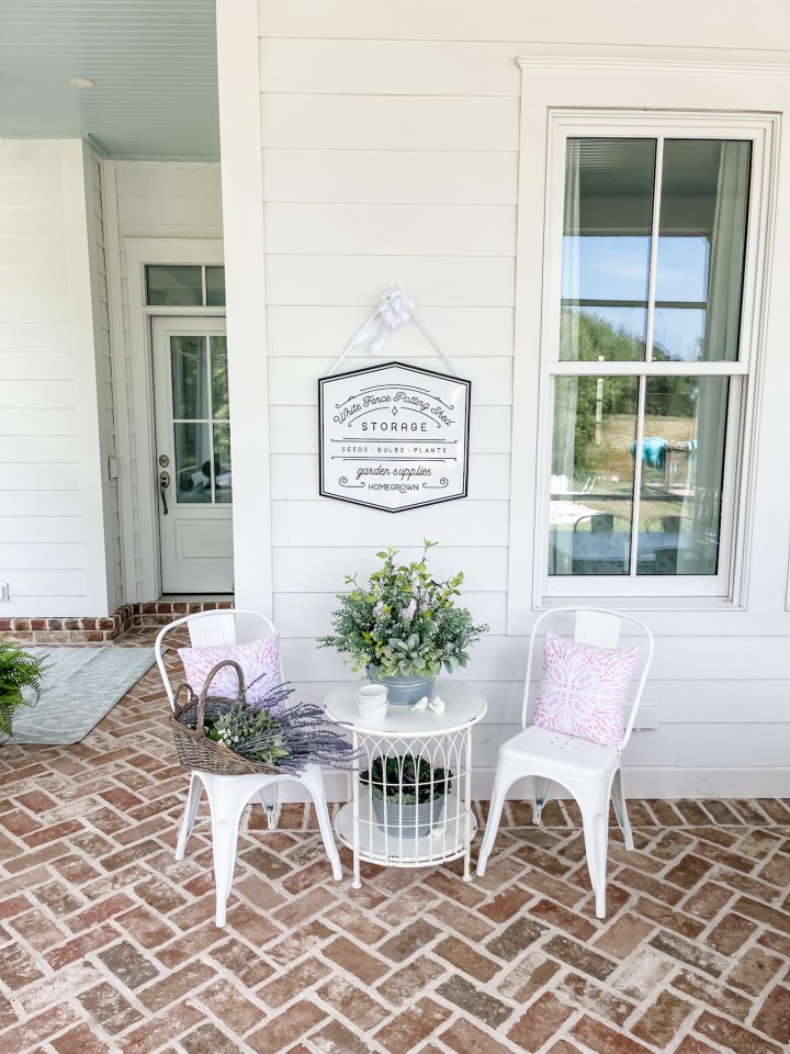 brick screened in porch with table and chairs