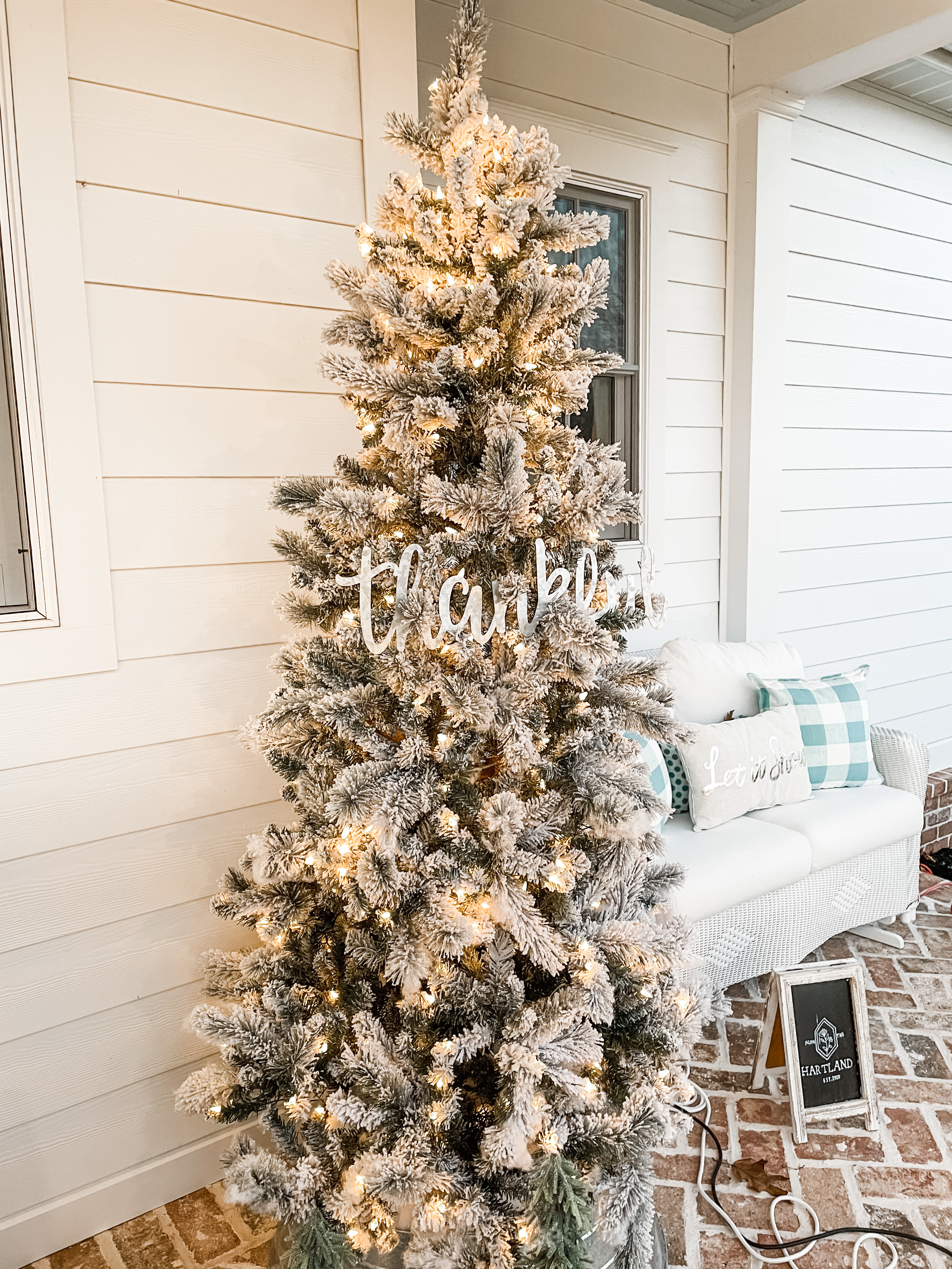 Flocked Christmas tree on a brick front porch