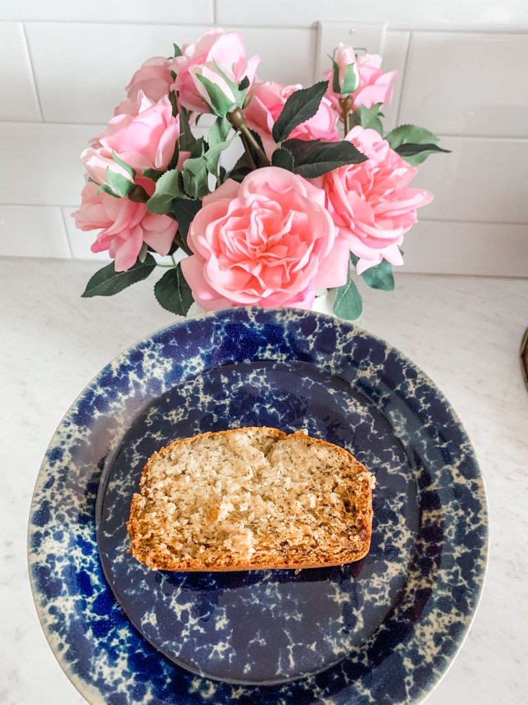 Gluten free banana bread on a blue plate with a pink flower