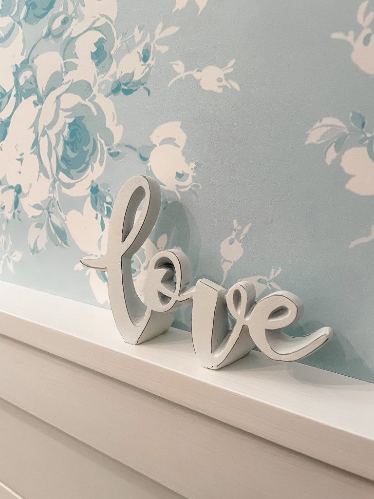 wallpaper in a powder room with a white love sign