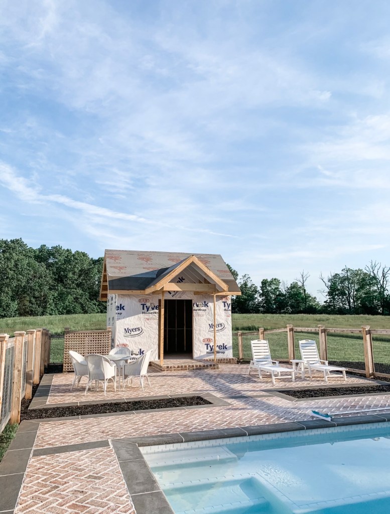 in-ground pool with a pool house under construction