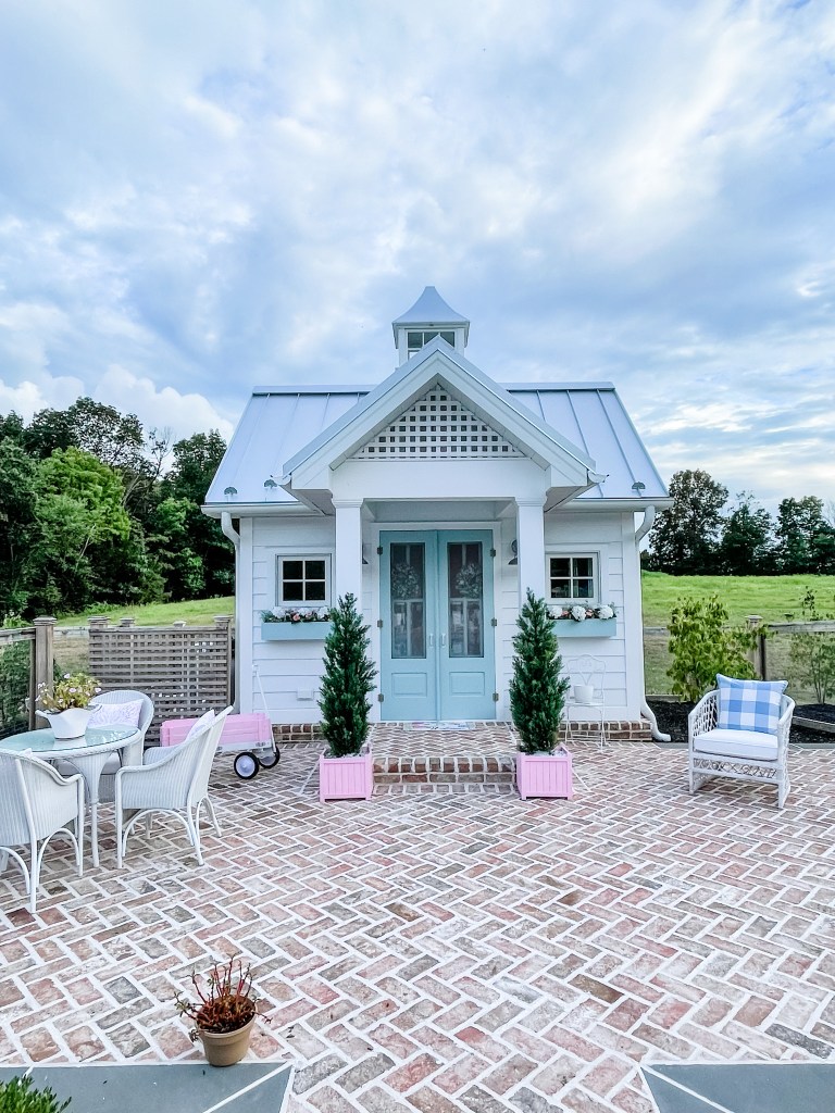 White pool house with metal roof and blue doors