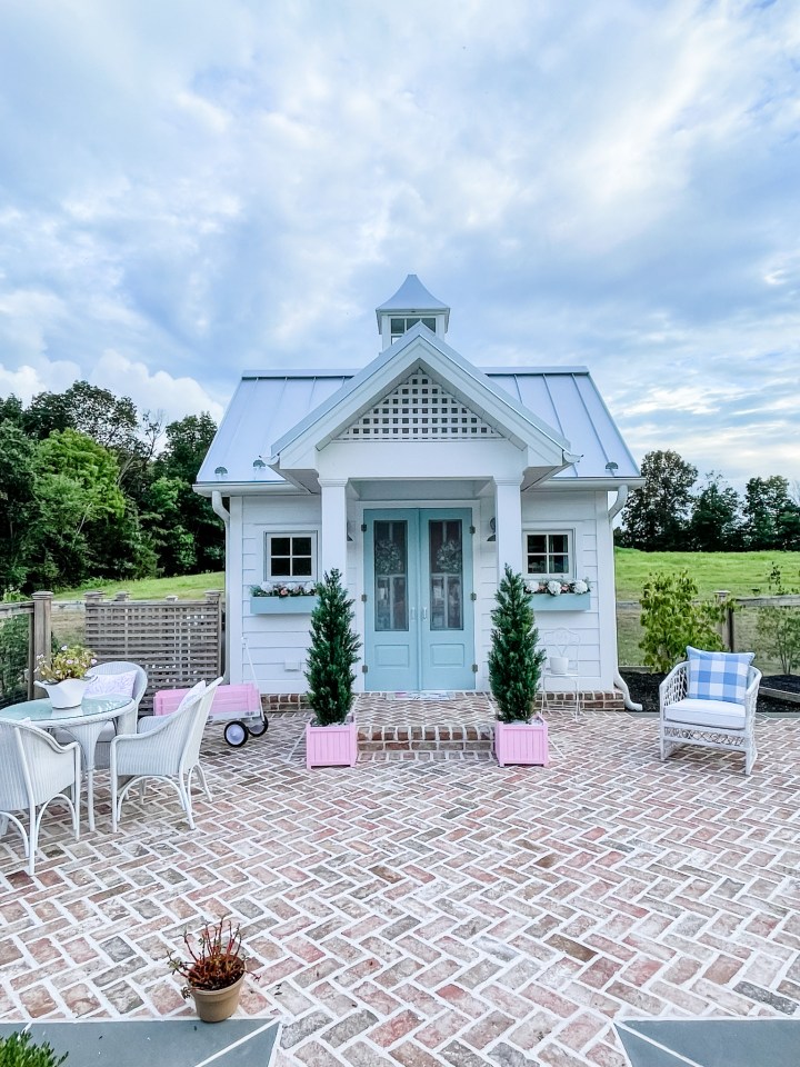 White pool house with metal roof and blue doors
